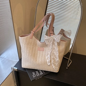 Straw woven tote bag with pink leather handles and delicate lace bow detail