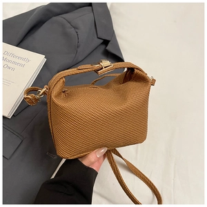 Close-up of brown woven texture mini crossbody bag with elegant gold metal clasp closure