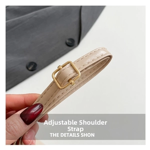 Detail of adjustable beige leather strap with gold buckle and fine double stitching