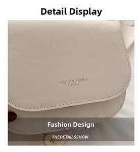 Detail of cream glossy faux leather bag with FASHION TREND EST 1996 embossed text
