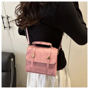 Detail of pink vintage square bag with fine textured leather and golden stud accents