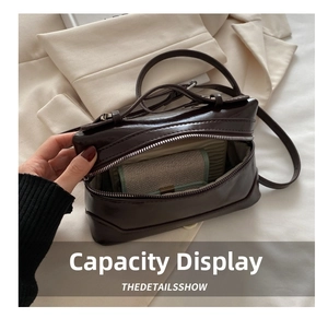 Detail of spacious interior in dark brown patent leather box bag with zipper opening