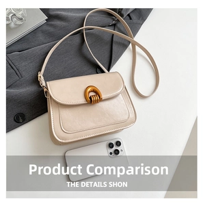 Detail of cream saddle bag featuring leather texture and golden U-shaped metal buckle