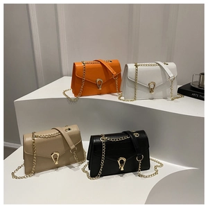 Detail view of four-color alligator texture chain crossbody bags on display stands