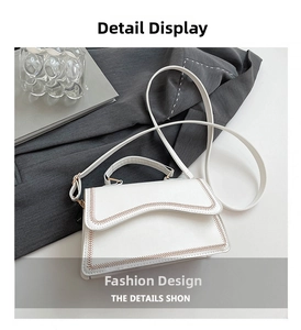 White leather handbag detail featuring brown wavy stitching on the flap and slim strap