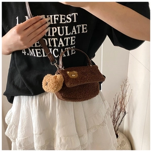 Vue détaillée du sac bandoulière en peluche marron avec broderie ours et texture douce