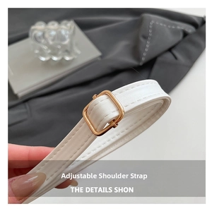 Close-up of adjustable white leather strap with premium gold metal buckle for shoulder bag