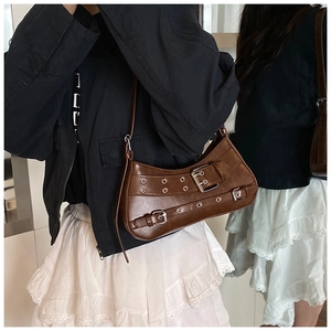 Detail view of brown vintage crescent shoulder bag with silver buckles and Y2K metal eyelets