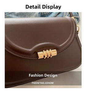 Close-up of a dark brown leather crossbody bag featuring a unique spiral gold buckle