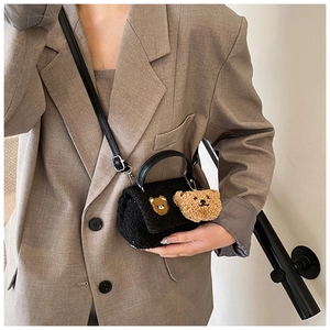 Détail du sac carré en peluche noire avec broderie ours et bandoulière en cuir