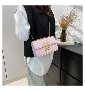 Detail view of pink quilted chain bag worn by a model to show product scale and fit