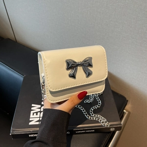 Minimalist cream white crossbody bag with silver metal bow and thin chain strap