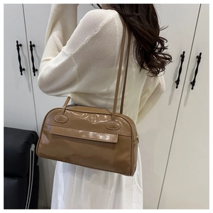 Dettaglio di una borsa Boston in pelle verniciata marrone con doppia zip e tracolla