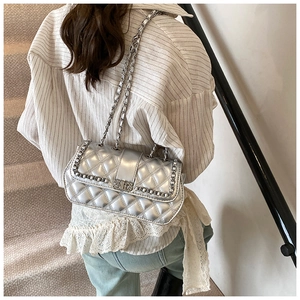 Detailed view of silver quilted chain bag featuring elegant diamond lattice stitching