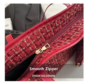 Detail shot of smooth golden metal zipper on red tweed shoulder bag with woven texture