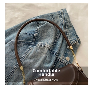 Detailed view of dark brown leather handbag with gold chain links and circular top handle