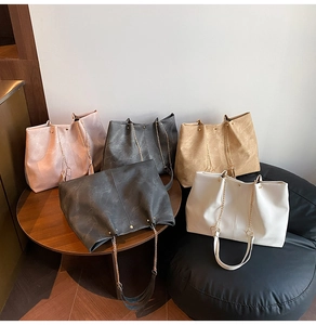 Group shot of colorful tote bags with marble texture and gold chain straps on furniture