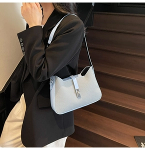 Detail of blue leather trim underarm bag with cat ear shape and silver buckle closure