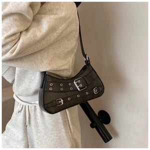 Detail of dark grey Y2K style shoulder bag featuring metal eyelets and buckle straps