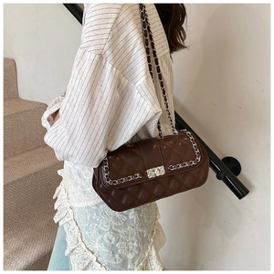 Detail of dark brown quilted leather crossbody bag with silver twist lock and chain strap