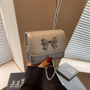 Silver bow-accented mini crossbody bag with delicate chain strap for stylish women
