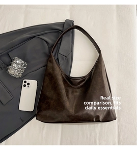 Detailed macro shot of large brown tote bag with vintage matte PU leather texture