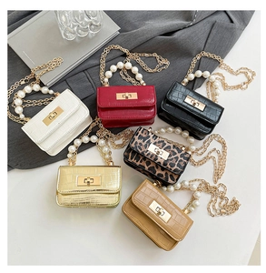 Détail de mini sacs à motif crocodile avec poignées en perles et chaînes dorées en couleurs