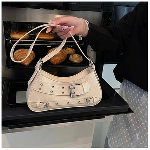 Close-up of beige Y2K style shoulder bag with vintage buckle details on an oven background