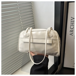 Dettaglio di una borsa a spalla in pelle bianco crema con trama liscia e cuciture decorative