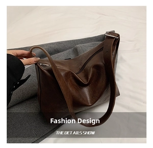 Detailed shot of dark brown vintage faux leather shoulder bag with silver buckle and zipper