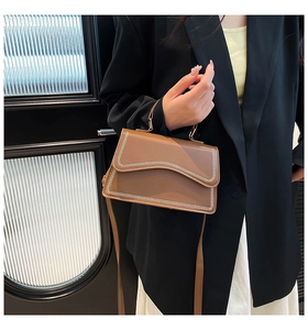 Caramel brown handbag with white contrast stitching detail shown on model side profile