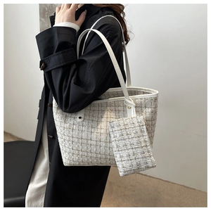 Detail of tweed tote bag set featuring woven texture and white leather trimming
