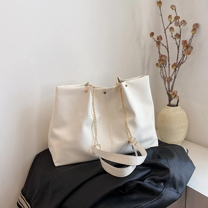 Minimalist beige pebble leather tote bag with gold chain strap for daily commuting