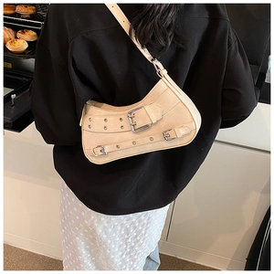 Chic beige crescent shoulder bag with metallic buckle details shown on a model