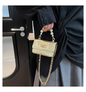 Détail du mini sac doré à motif croco avec anse en perles et chaîne métallique