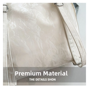 Macro detail of glossy wrinkled white leather and denim patchwork on a tote bag