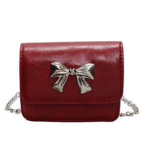 Elegant red patent leather crossbody bag with silver bow accent and chain strap
