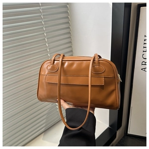 Dettaglio della finitura in pelle PU marrone liscia e dei doppi spallacci della borsa bowling