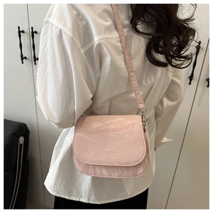 Pink saddle crossbody bag with pleated texture and Fashion Trend text detail