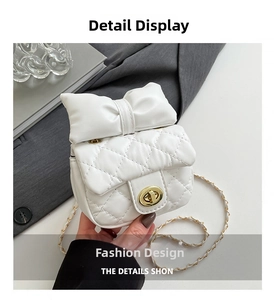 Detail of white quilted mini bag featuring a large bow and gold chain strap