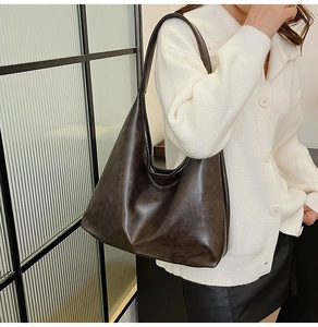 Vue détaillée du grand sac hobo en cuir marron foncé porté avec une tenue décontractée