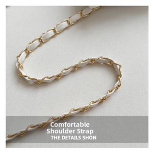 Detail of white leather and gold metal chain strap showing fine braided craftsmanship