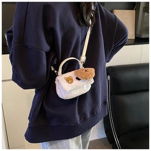 Vue détaillée du sac bandoulière en peluche blanche avec broderie d'ours et charm
