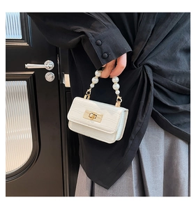 Detail showing white crocodile pattern texture with pearl handle and gold rotary lock