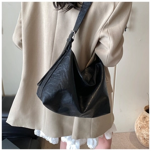 Détail du sac hobo noir montrant la bandoulière réglable et le cuir vintage plissé texturé