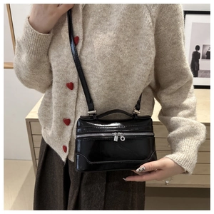 Minimalist black square crossbody bag styled with a beige cardigan and brown skirt