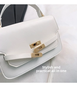 Detail of white leather handbag with elegant gold metal twist lock and strap buckle