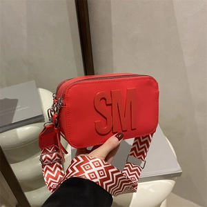 Borsa a tracolla rossa con lettere SM e tracolla larga a motivi geometrici