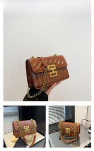 Detailed view of brown crossbody bag with embossed texture and gold chain strap