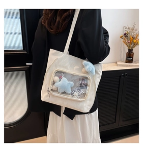 Detailed view of a white nylon ita bag with a clear PVC window for plush decorations